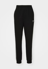 Svarta sweatpants i bomullsblandning, med elastisk midja, avslutning vid anklarna och vita sidosträck. Litet logotyp vid höften.