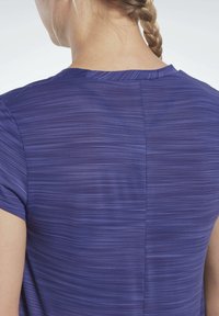 Fialový top s krátkým rukávem, zdobený jemným horizontálním pruhem, hladkou texturou a decentním švem podél zadního středu.
