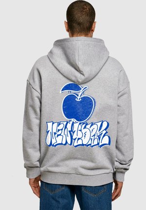 Grauer Kapuzenpullover mit einem blauen Apfelgrafik und "NEW YORK" in fetter, stilisierter blauer Schrift auf dem Rücken. Stoff aus Baumwollmischung.