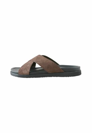 Brown cross-strap sandals with textured fabric upper, black synthetic sole, and flat design, suitable for casual wear.