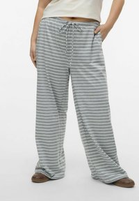 Pantalones de pierna ancha a rayas grises, fabricados en tejido suave. Cuentan con una cintura elástica con cordón y bolsillos laterales.