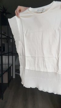Bijela majica s nabranim detaljima na rubu i rukavima. Glatka tkanina s opuštenim krojem i okruglim izrezom. Oznaka: "ANNA FIELD."