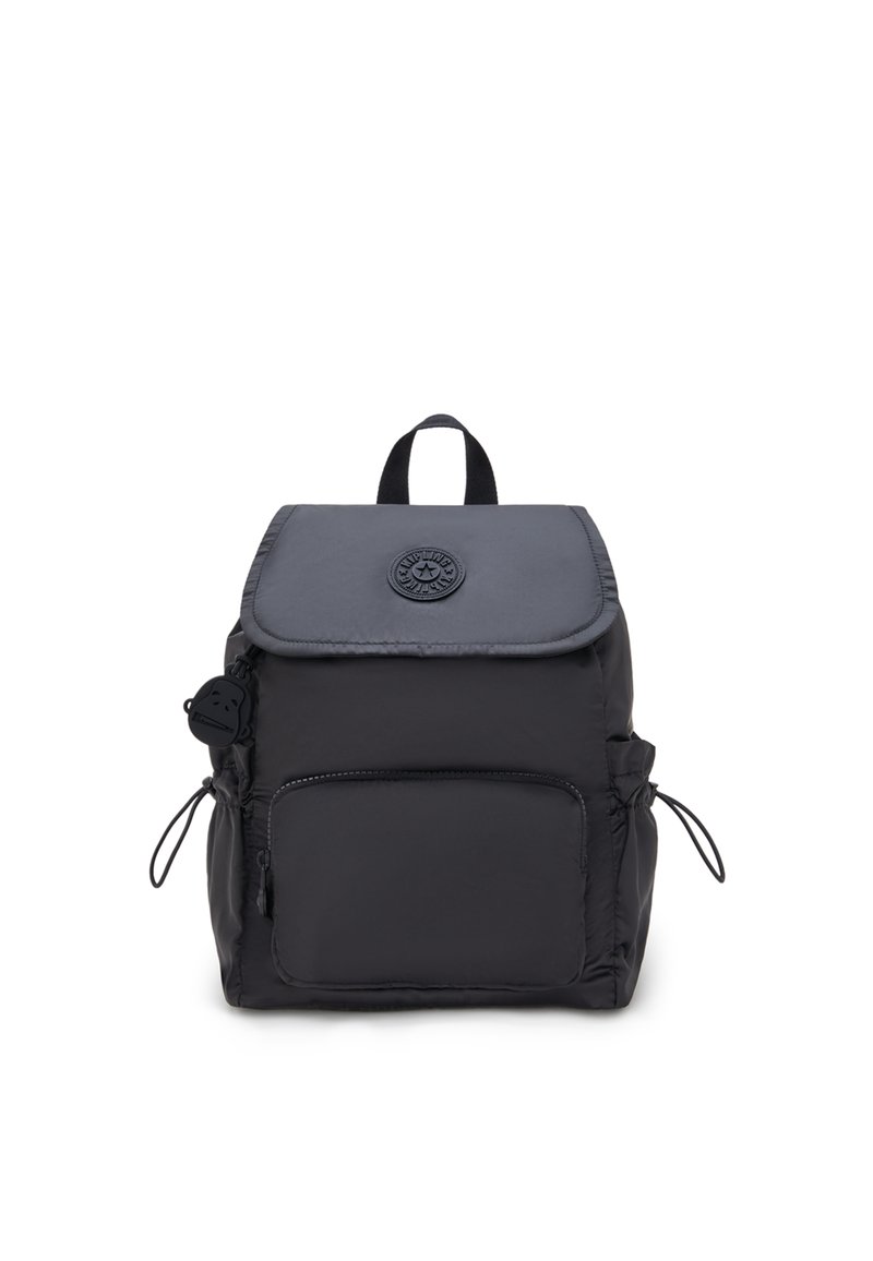 Sac à dos en nylon noir avec un rabat, une poche avant et des fermetures à cordon sur les côtés. Présente un logo rond et une poignée supérieure. Texture douce et lisse.