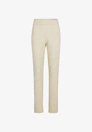 Beige, nauwsluitende legging gemaakt van zacht, rekbaar materiaal met een gladde textuur, zonder zichtbare patronen of hardware. Enkelhoge lengte.