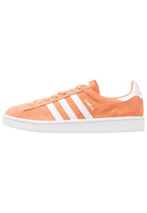 Oranger Adidas Campus Wildleder-Sneaker mit weißen Streifen, weißer Sohle und Schnürsenkeln, von der Außenseite gezeigt.