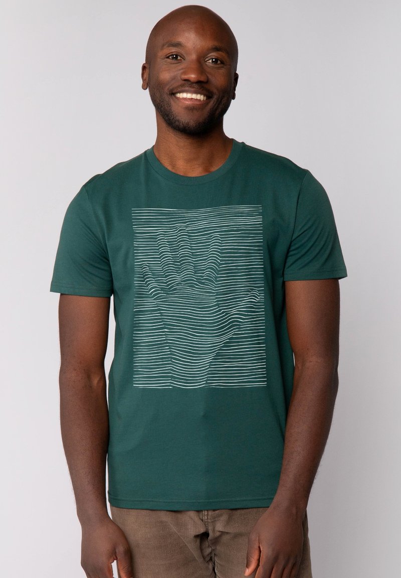 Groene katoenen t-shirt met een witte lineaire handgrafiek op de voorkant. Korte mouwen en een ronde hals. Zachte textuur.