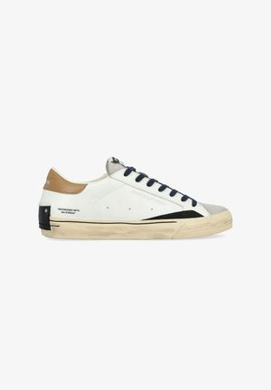 Sneaker bianco in pelle con lacci blu navy, dettagli color cammello e punta testurizzata. Presenta una striscia laterale nera e una suola invecchiata con dettagli del logo.