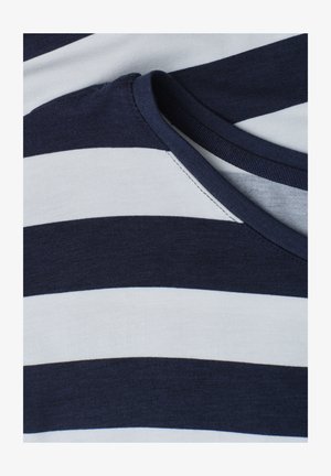 Zbliżenie na tkaninę w poziome paski w kolorze granatowym i białym z granatowym prążkowanym szwem przy dekolcie.