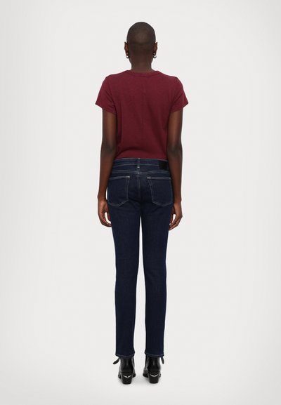 Maroon short-sleeve top paired with dark blue jeans. The jeans feature a classic fit with back pockets and slight cuff detail at the hem.
