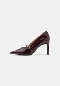 Patent burgunder høyhælte sko med spiss tå, ankelrem med gullbeslag og en glatt, polert finish. Hevet stiletthel.