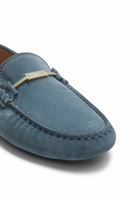 Blå mocka loafers med rund tå, dekorativ söm och en accent i guldfärg. Mjuk textur och strömlinjeformad design.