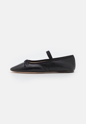 Black leather ballet flat with pointed toe, bow detail at the front, elastic strap, and minimalistic design. Smooth texture with a flexible sole.