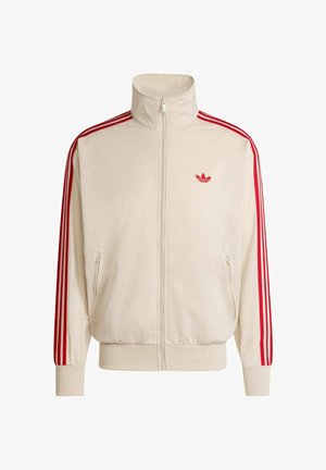 Kremowa bluza sportowa na zamek błyskawiczny z czerwonymi paskami na rękawach i czerwonym logo na lewej piersi, wyposażona w ściągacze na rękawach i w pasie.