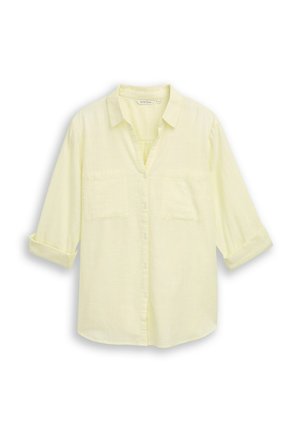 Hellgelbes langärmliges Hemd mit Knöpfen, Kragen, zwei Brusttaschen und hochgekrempelten Ärmeln bis zu den Ellbogen.
