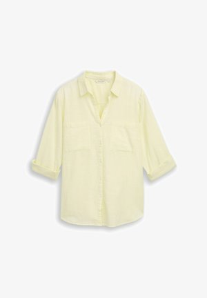 Hellgelbes langärmliges Hemd mit Knöpfen, Kragen, zwei Brusttaschen und hochgekrempelten Ärmeln bis zu den Ellbogen.