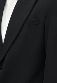 Sort blazer med glat tekstur, enkelt knaplukning og brystlomme. Stoffet har en skræddersyet pasform med rene linjer.