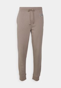 Grå sweatpants gjorda av mjukt bomull med elastisk midja, justerbar dragsko och logodetalj på vänstra låret.