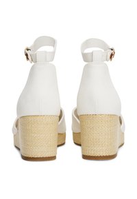 Witte canvas wedge sandalen met een geweven jute hak. Voorzien van een verstelbare enkelriem en open teenontwerp. Soepele textuur en neutrale kleur.