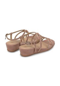 I sandali in suede rosa presentano numerose cinghie incrociate decorate con piccoli strass, una suola platform e una fibbia argentata su una cinghia alla caviglia.