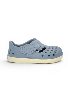 Sandale en caoutchouc bleu clair pour enfant avec des trous de ventilation, bride ajustable étiquetée "igor," et une semelle beige.