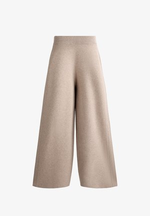Pantaloni beige a gamba larga realizzati in tessuto a maglia, dotati di un elastico in vita a coste e una texture liscia, con linee pulite e semplici e senza chiusure visibili.