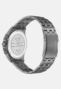 Sidabrinis metalinis laikrodis, turintis apvalų korpusą, nerūdijančio plieno grandinėlę ir apskritu ornamentu dekoruotą ciferblatą su "POLICE" ženklu.