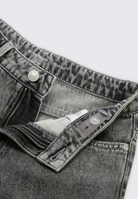 Jeans din denim gri cu un brâu cu model, fermoar și închidere cu nasture. Include o pungă frontală și detalii cusute.