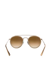 Occhiali da sole con lenti a gradiente marrone, montatura in bronzo metallico, lenti rotonde e aste sottili. Cuscinetti nasali regolabili per una vestibilità confortevole.