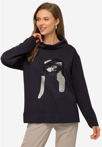 Felpa nera con collo a cappuccio, caratterizzata da una grafica sul davanti e una texture liscia. Maniche lunghe e vestibilità rilassata.