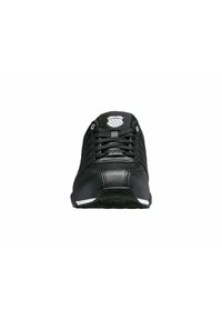 Schwarzer Sportschuh mit einem glatten Lederobermaterial, strukturierten Seiten, runder Zehenpartie, Schnürverschluss und einem weißen Akzent an der Sohle.