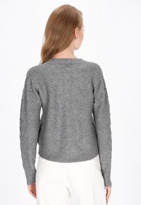 Grauer Strickpullover mit strukturiertem Zickzackmuster, geripptem Saum und Bündchen sowie einem leicht verkürzten Design auf der Rückseite.