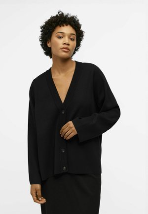 Cardigan noir avec un décolleté en V profond, des manches longues et cinq boutons à l'avant. Fabriqué dans un tissu doux et texturé avec une coupe décontractée.