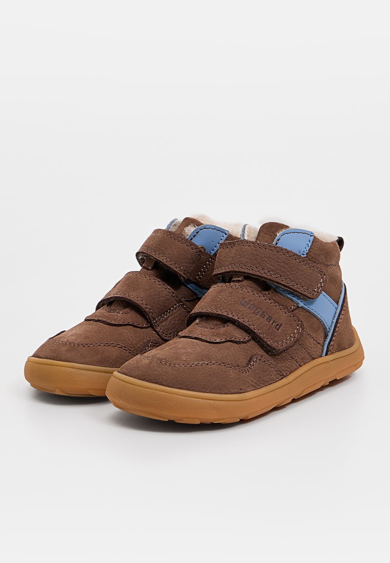 Bottes en suède marron avec des accents bleus, deux bandes Velcro et une doublure douce et texturée. Semelles en caoutchouc pour une meilleure adhérence, design bas.