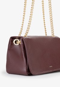 Borsa testurizzata bordeaux con design a stampa di serpente, dotata di una tracolla in catena dorata e accenti in oro sui lati.