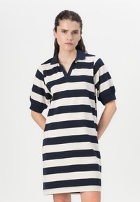 Φόρεμα τύπου πόλο σε ναυτικό και κρεμ οριζόντιες ρίγες, με κολάρο, κοντά μανίκια και άνετη εφαρμογή. Λείο, αναπνεύσιμο ύφασμα.