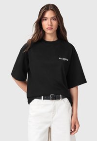 Maglietta nera a maniche corte con scollo rotondo, con il logo "ALLSAINTS" bianco sul lato sinistro del petto. Tessuto di cotone liscio.