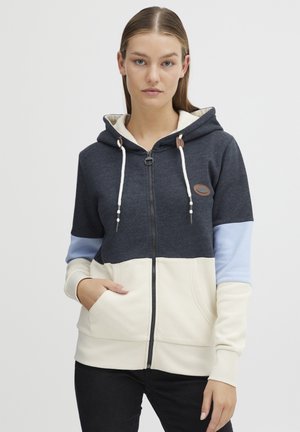 Sweat à capuche zippé en gris foncé, crème et bleu clair. Comprend des poches avant, des cordons de serrage et un patch logo en caoutchouc. Tissu en mélange de coton.