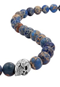 Perlenkette mit runden, blau und braun marmorierten Steinen und einem silbernen Totenkopf-Akzent. Glatte Textur und abwechslungsreiche Farbmustern.