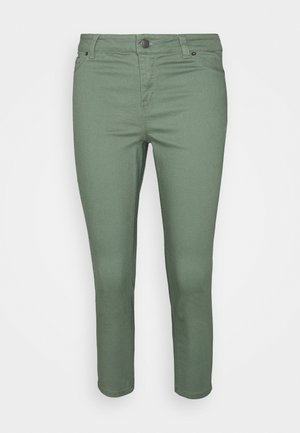 Calças de ganga verdes com um design slim-fit, apresentando um fecho de botão, cinco bolsos e uma textura suave. Cintura de altura média.