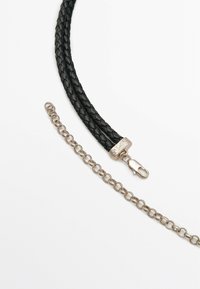 Cordino in pelle nera intrecciata con hardware galvanizzato argento, dotato di una chiusura e di una seconda catena argento con anelli circolari.
