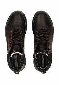 Botas de cuero marrón hasta el tobillo con acentos de tela negra, que presentan cordones, forro de piel de oveja y suela de goma. Talla 42 visible en el interior.