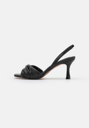 Sort læder slingback sandal med rynket frontrem og afsmalnet mellemhøj hæl på hvid baggrund.