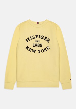 Żółta bluza z długim rękawem z prążkowanymi ściągaczami przy mankietach i dekolcie, z czarnym napisem "HILFIGER EST. 1985 NEW YORK" z przodu.