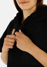 Schwarzer Frottee-Hoodie mit einer geräumigen Kapuze, der eine strukturierte Oberfläche, Kordelzüge und einen lässigen Schnitt bietet.