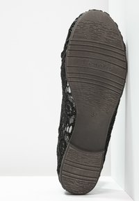 Scarpa nera in pizzo con suola in gomma testurizzata, caratterizzata da motivi floreali e un design cucito lungo i bordi, contrassegnata con la taglia 37.