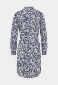 Abito floreale con sfondo blu navy decorato da fiori blu chiaro e bianchi, maniche lunghe, colletto e una linea vita aderente.