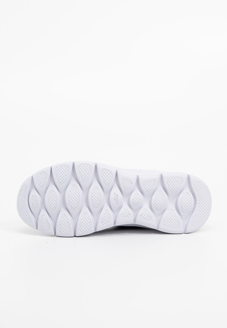 Suela de zapato deportivo blanca con una superficie texturizada, que presenta goma, un patrón ondulado y almohadillas de agarre colocadas estratégicamente.
