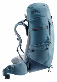 Light blue backpack with a rounded top, padded back, adjustable straps, and multiple external pockets. Textured fabric and sturdy hardware.