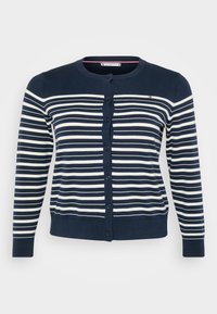 Σκούρο μπλε ζακέτα με οριζόντιες λευκές ρίγες, διαθέτει στρογγυλή λαιμόκοψη και κουμπιά μπροστά. Ριπ σχέδιο στο τελείωμα και στα μανίκια. Μαλακή, λεία υφή.