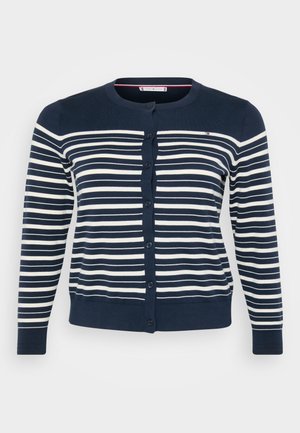 Námorně modrý kardigan s horizontálními bílými pruhy, s kulatým výstřihem a knoflíkovým zapínáním. Ribkované zakončení a manžety. Měkká, hladká textura.
